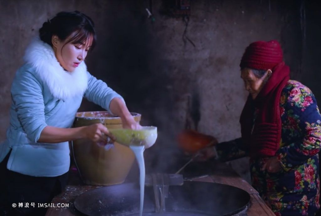 李子柒用红薯提取淀粉做成面糊,制作传统粉条,然后在祖母帮助下过滤,放进沸水中。